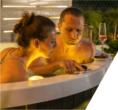 A couple sits in a hot tub, sharing a peaceful and intimate experience in a warm, bubbling environment