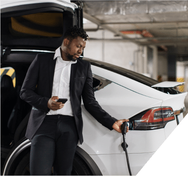 A man finishes charging his electric vehicle and removes the charging cable, ready to depart