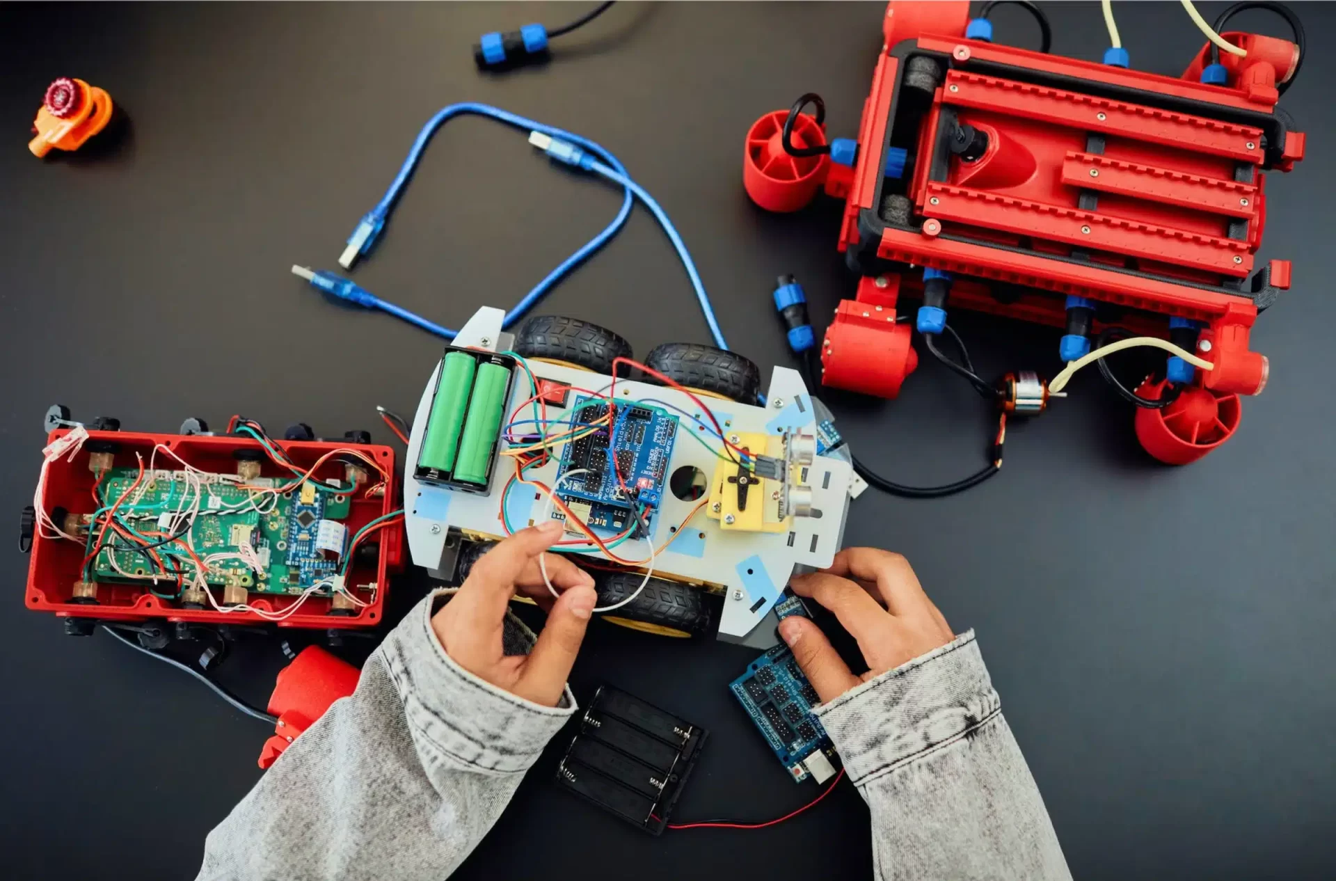 Electrical Maintenance as a man works on robotics, assembling components with precision and focus in a well-equipped workshop