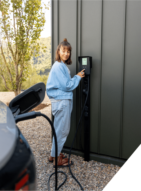 EV Charger Installation as a woman connects her electric vehicle to a charging station, preparing for an efficient charge